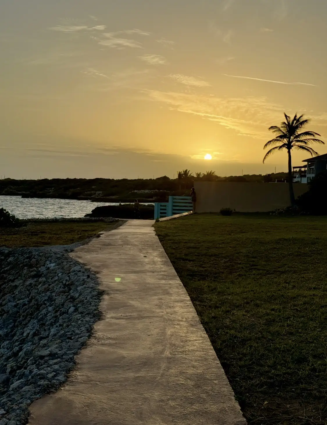 Sunset pathway leading to the waterfront at Villa Bénie